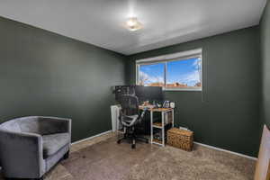Carpeted home office featuring baseboards