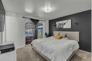 Carpeted bedroom with an accent wall and wallpapered walls