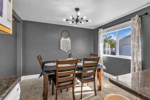 Dining area featuring a chandelier and light colored carpet