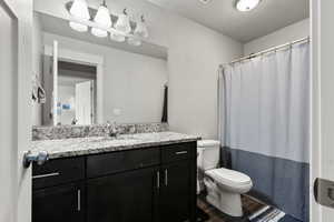Full bath with vanity and dark wood finished floors