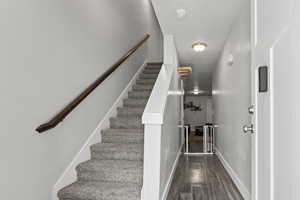 Staircase with wood finished floors and baseboards