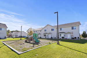 Communal playground featuring a yard and a residential view