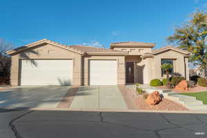 View of front of house featuring a tile roof, stucco siding, concrete driveway, and a garage