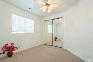 Unfurnished bedroom with carpet floors, ceiling fan, and a closet