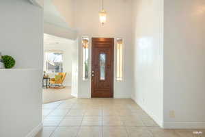 Entrance foyer featuring light tile patterned floors and a towering ceiling
