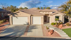 Mediterranean / spanish-style house with stucco siding, an attached garage, concrete driveway, and a tile roof