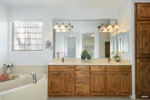 Full bathroom with double vanity, a bath, and light tile patterned flooring