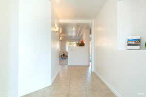 Hall with light tile patterned floors and baseboards