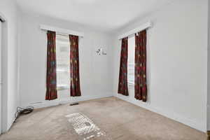 Carpeted spare room featuring a textured ceiling and baseboards