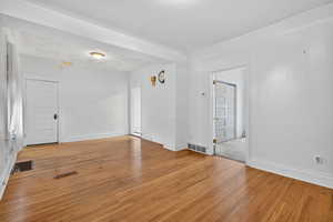 Unfurnished room with light wood-type flooring and a textured ceiling