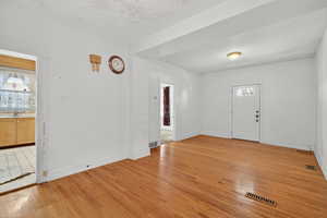 Entryway with light wood-type flooring and a textured ceiling