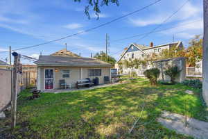 Back of house featuring a patio, a fenced backyard, and a shed