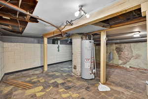 Unfinished basement featuring water heater
