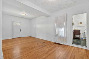 Foyer entrance with light wood-style floors and a textured ceiling