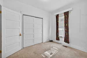 Unfurnished bedroom with carpet, a textured ceiling, and a closet