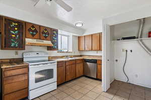 Kitchen with white range with electric cooktop, a textured ceiling, dishwasher, brown cabinets, and under cabinet range hood