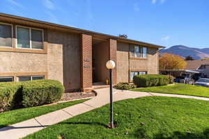 View of front facade featuring a front yard, stucco siding, and a mountain view