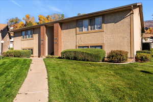 View of front of property featuring stucco siding and a front lawn