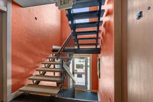Staircase with a textured wall and a towering ceiling
