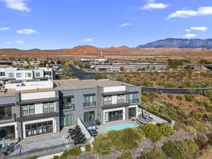 Rear view of house with a patio area, a mountain view, a standing seam roof, and a metal roof