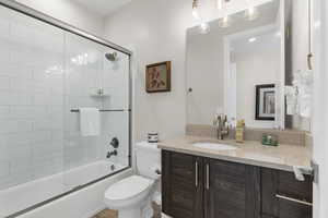 Full bathroom featuring vanity and shower / bath combination with glass door