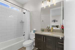 Bathroom featuring vanity, shower / bath combo, and light tile patterned floors