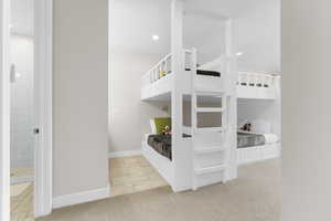 Unfurnished bedroom featuring light carpet, connected bathroom, and recessed lighting