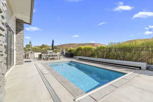 View of swimming pool featuring a mountain view, a patio, a fenced backyard, and outdoor dining area