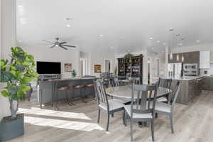 Dining area with light wood-style floors and recessed lighting