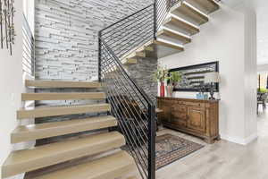 Staircase with wood finished floors and baseboards