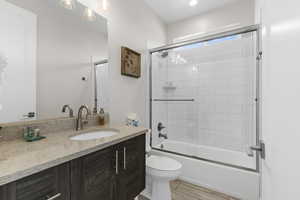 Full bath featuring vanity and bath / shower combo with glass door