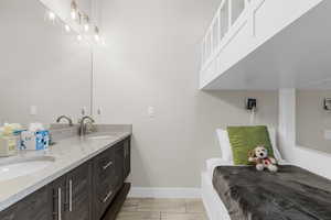 Full bath featuring double vanity and baseboards