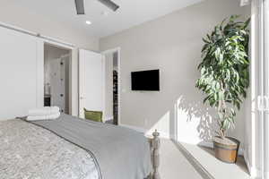 Bedroom with a barn door, carpet flooring, recessed lighting, and ceiling fan