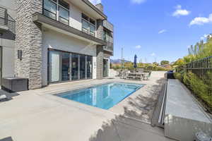 View of pool featuring a patio area, a balcony, and outdoor dining space
