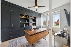 Office area with a ceiling fan and light wood-style floors
