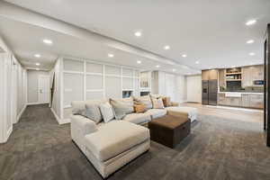 Carpeted living room featuring recessed lighting and a sink