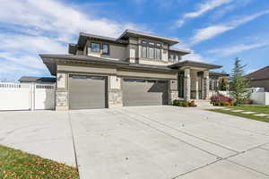Prairie-style home featuring a garage, concrete driveway, and stone siding
