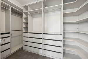Walk in closet with dark colored carpet