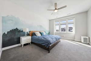 Carpeted bedroom featuring a ceiling fan and baseboards