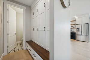 Mudroom featuring light wood-style flooring and baseboards