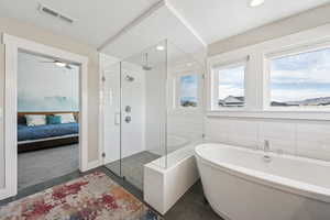 Ensuite bathroom featuring a soaking tub, a stall shower, tile walls, recessed lighting, and dark tile patterned flooring