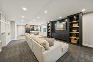 Living room featuring recessed lighting, dark carpet, and built in features