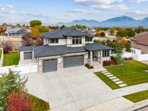Prairie-style house featuring driveway, a residential view, a garage, and stone siding