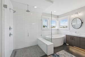Full bathroom with a soaking tub, tile walls, vanity, a stall shower, and recessed lighting