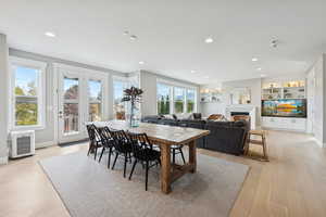 Dining area with light wood-style floors, a fireplace, recessed lighting, and built in features