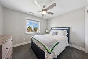 Bedroom featuring dark carpet and a ceiling fan