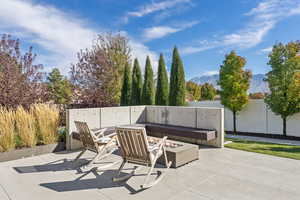 Fenced backyard with an outdoor fire pit, a patio, and a mountain view