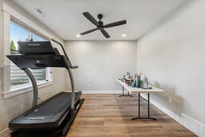 Workout area featuring light wood-style floors, recessed lighting, and ceiling fan