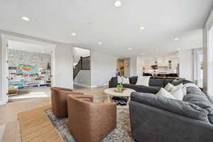 Living room featuring recessed lighting, wood finished floors, and stairway