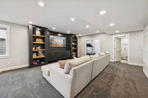 Living room with dark colored carpet and recessed lighting